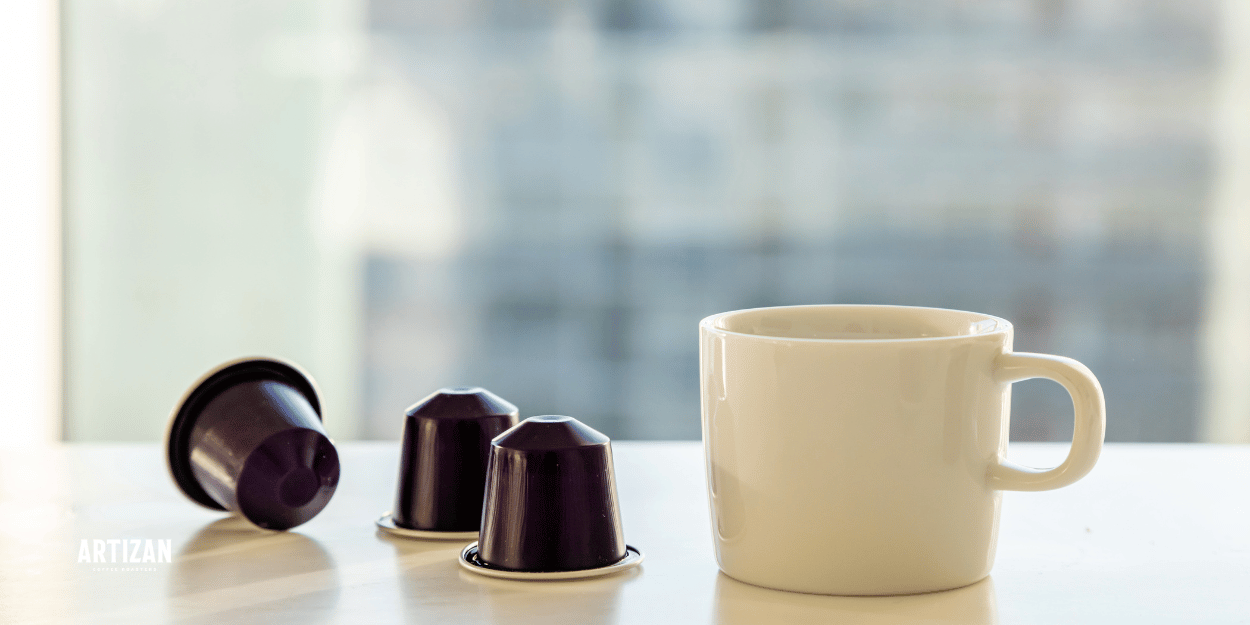 An image of a cup beside with coffee pods