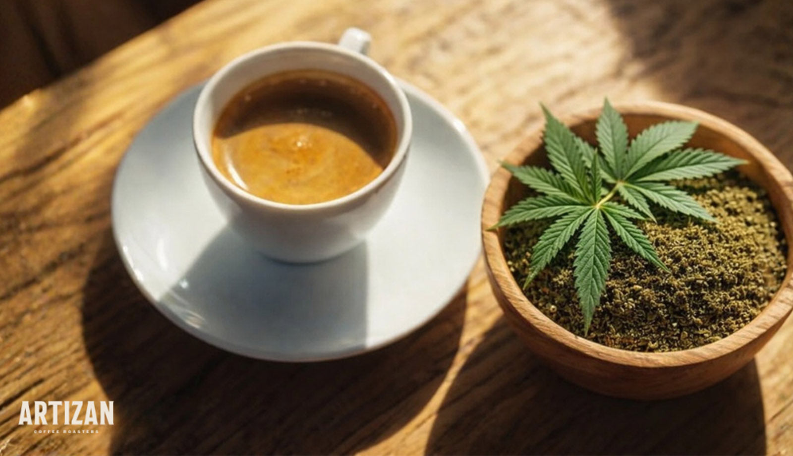 Espresso in a white cup beside a wooden bowl of ground hemp topped with a hemp leaf on a wooden table.