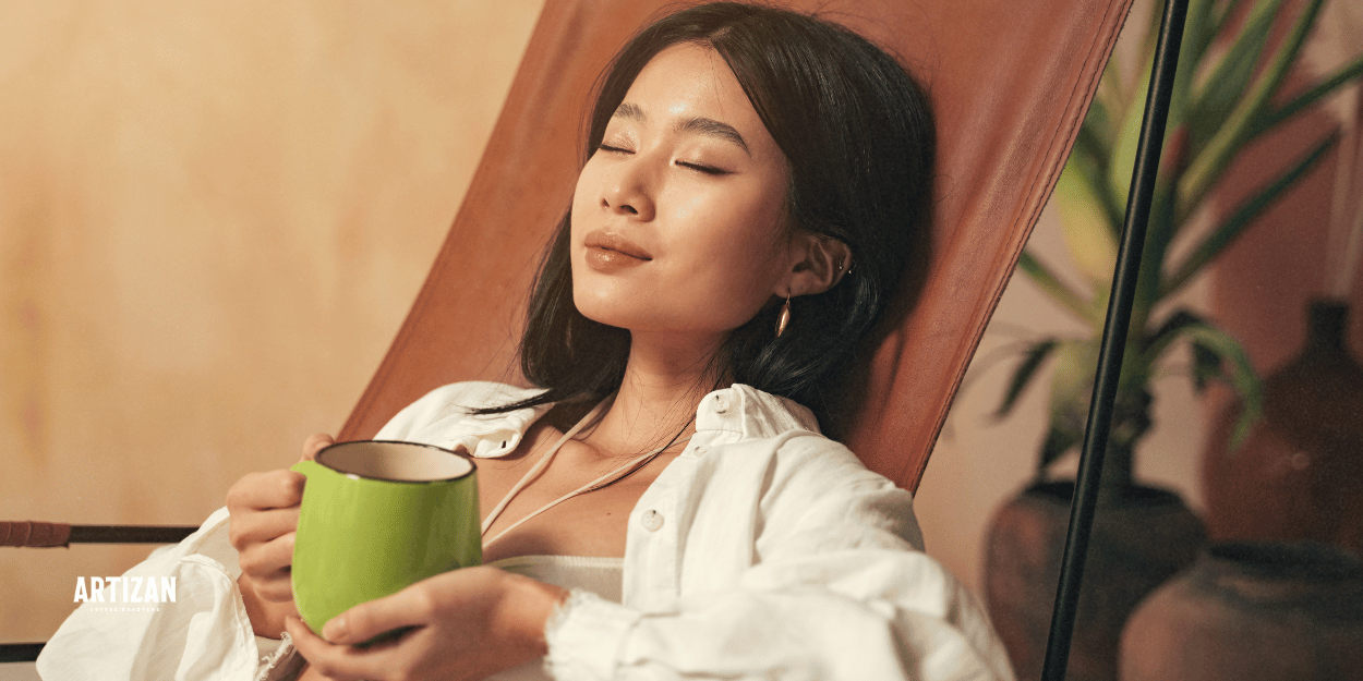 A woman relaxing while holding a cup of coffee