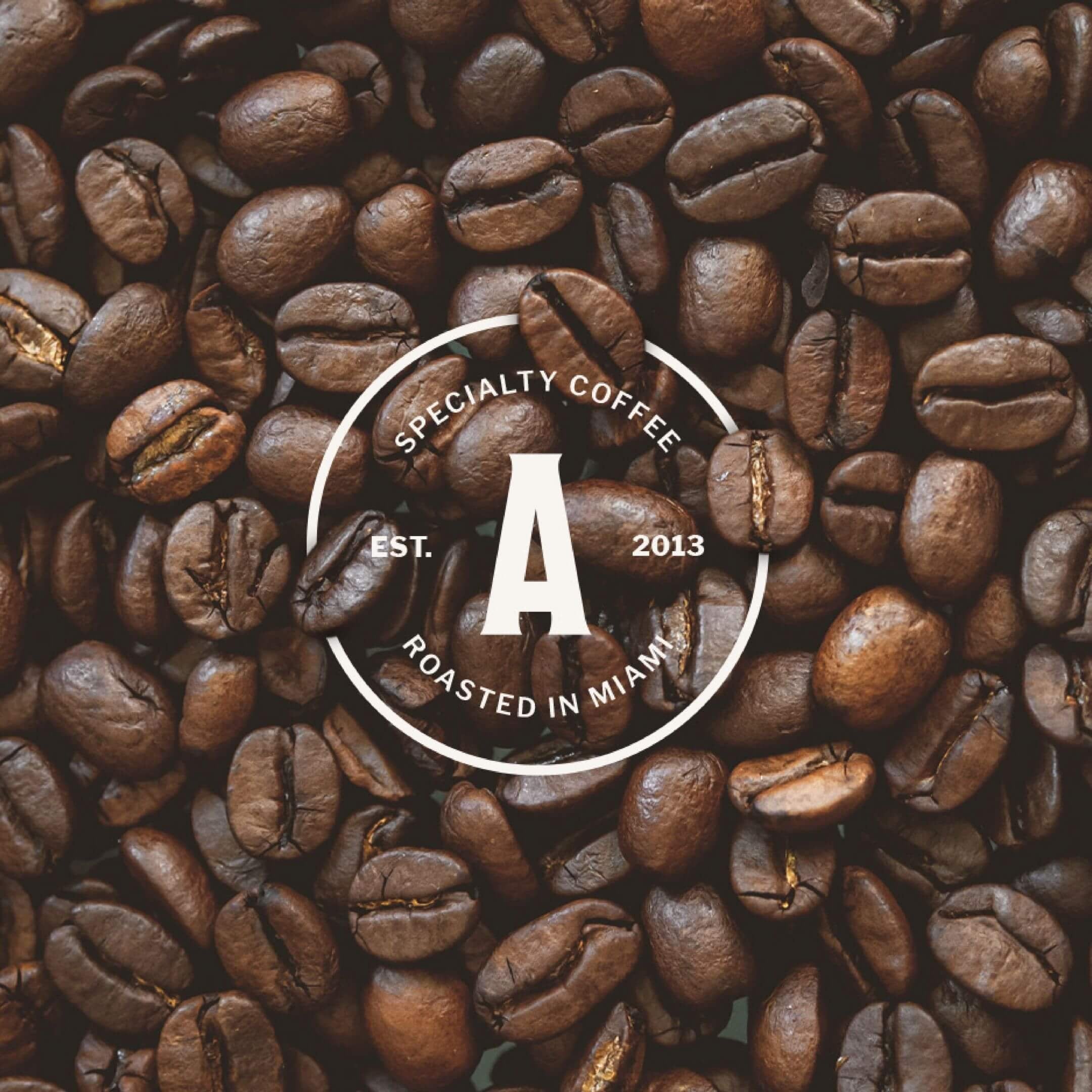 Artizan Coffee Roasters logo with the text “Specialty Coffee Established 2013, Roasted in Miami” over a background of roasted coffee beans.