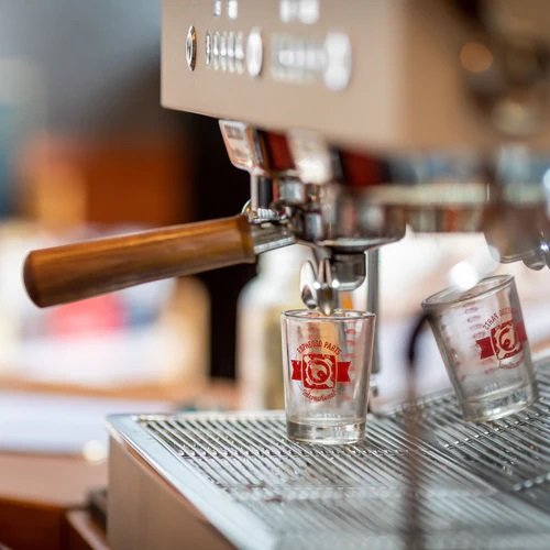 Close-up of Ascaso Barista T Plus 3 Group Espresso Machine brew group section, highlighting group heads, wooden steam lever handles, chrome accents, and the front control panel with digital displays.