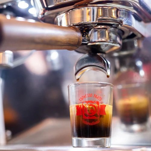 Close look of barista making coffee on Ascaso Barista T Plus Automatic 3 Group Espresso Machine.