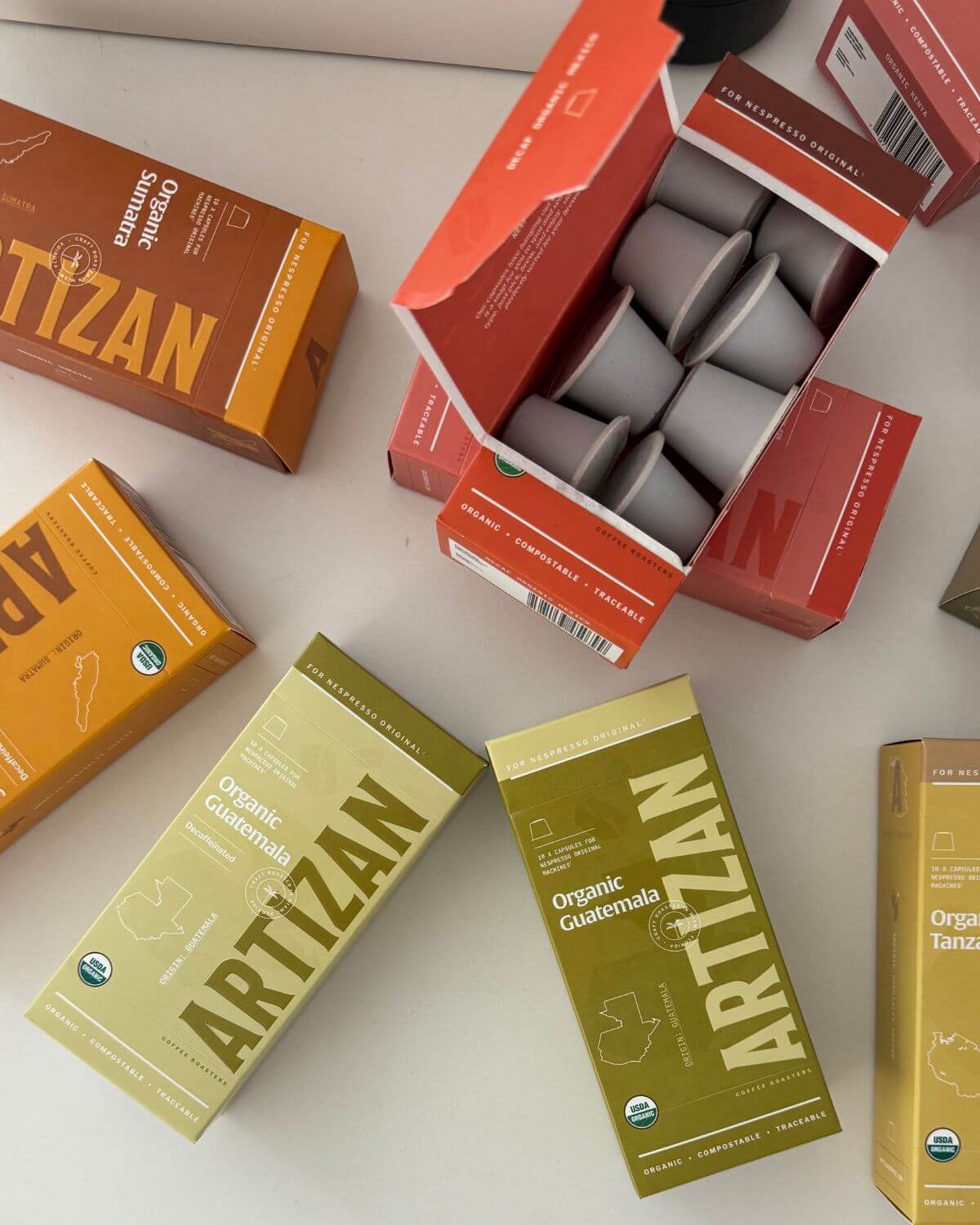 Artizan Coffee organic Nespresso-compatible pods in eco-friendly packaging, featuring blends like Organic Guatemala and Organic Tanzania