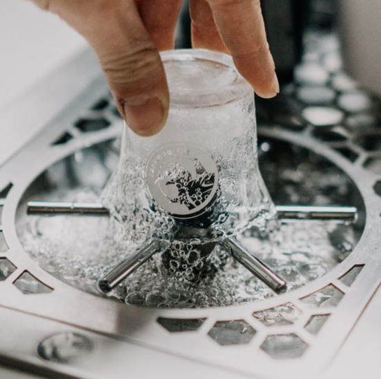An image of a man washing rinsing its glass on the Rhino Pitcher Rinser - 300mm Spinjet.