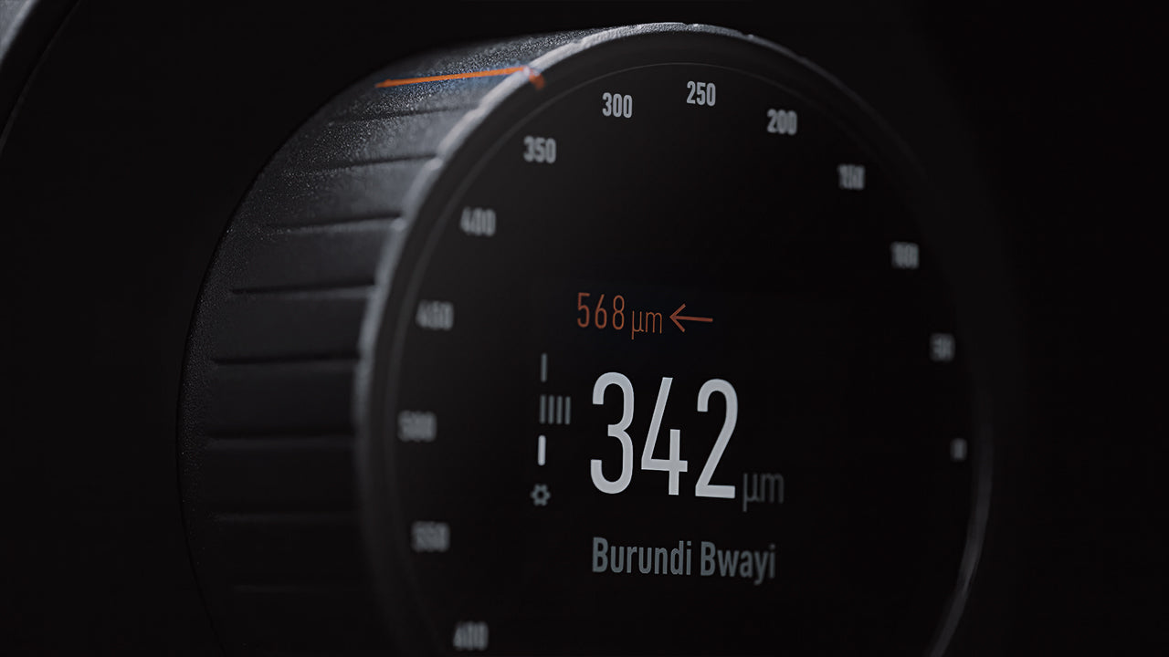 Close-up of a coffee grinder’s digital display showing grind size in microns, emphasizing precision and consistency.