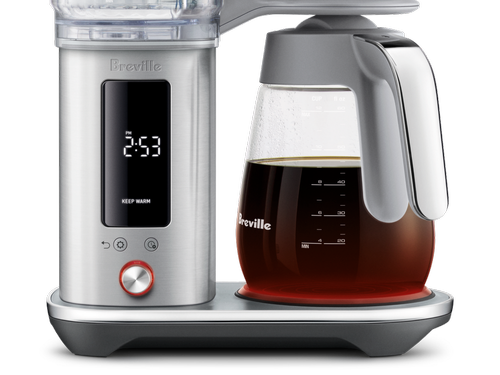 Close-up of The Luxe Brewer Glass programmable coffee maker digital display showing 2:53 Keep Warm, with silver control dial and Breville glass carafe marked with measurement lines.