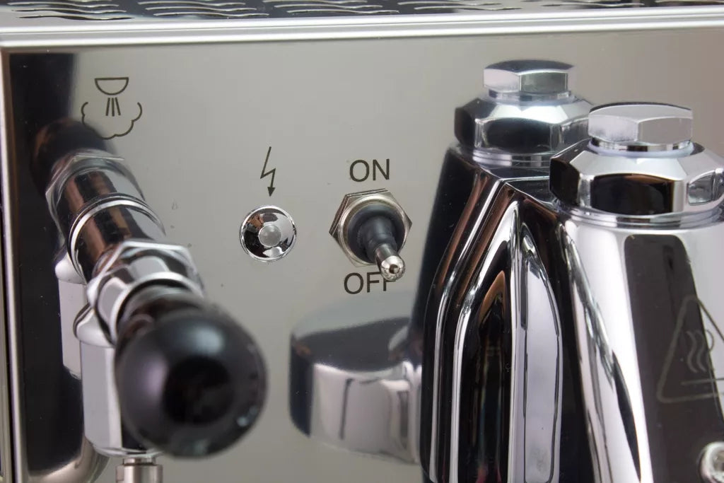 Close-up of Bezzera Mitica V2 HX espresso machine steam wand, on/off toggle, lightning symbol button, and chrome body.