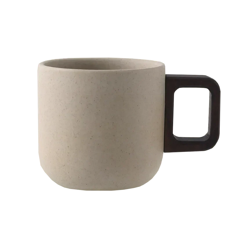 Cream ceramic mug with a dark handle, perfect for coffee or tea, modern design and durable material.