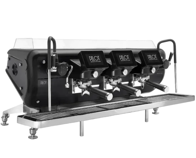A three-group Barista Attitude Pilot commercial espresso machine in a black finish with chrome accents is displayed. The machine features independent digital displays on each group head showing the name "PILOT", anti-scalding cool-touch steam wands, and a stainless steel drip tray.