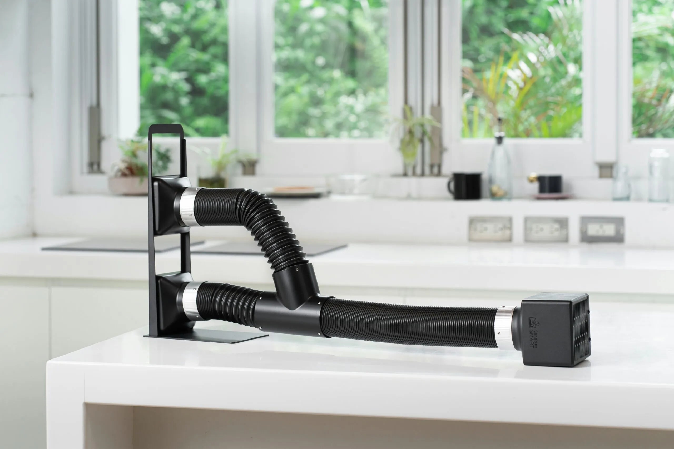 Sandbox Smart F2 Exhaust Fan attached to flexible black tubing, designed for venting roasting smoke from coffee roasters
