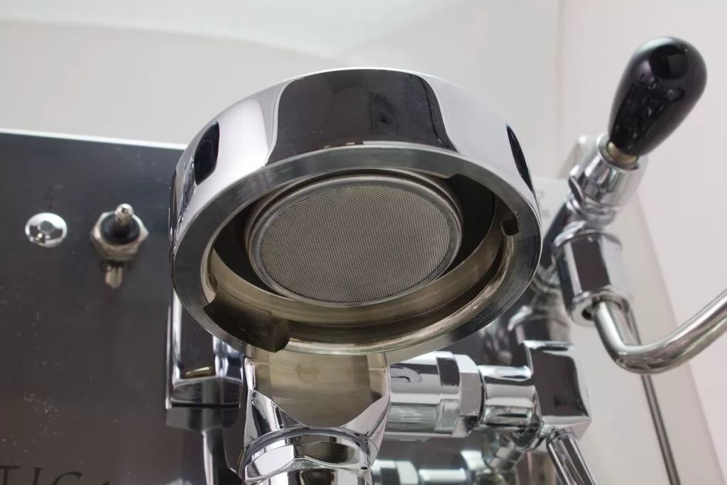 Close-up of Bezzera Mitica V2 HX espresso machine grouphead and portafilter with polished chrome finish.