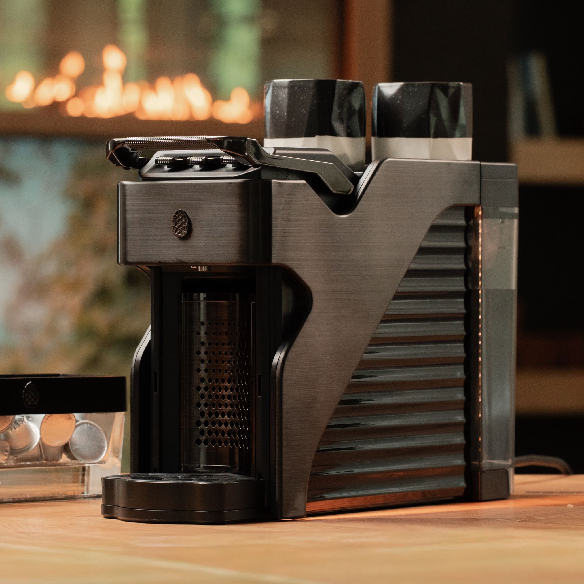 Line1 Espresso and Coffee Machine in Brushed Nickel and Onyx on wooden counter with warm ambient lighting