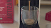 Cuba Mia organic Nespresso capsules shop of coffee brewing from a Nespresso machine into clear glass cup